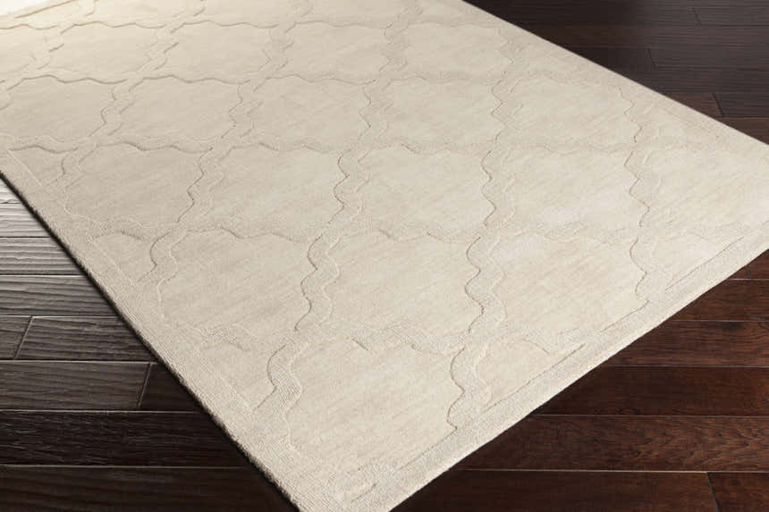 Close-up of the beige Orick Hand Loomed Wool Area Rug showing its geometric pattern and texture on dark wood floors. Corner