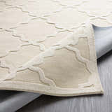 Close-up of the beige Orick Hand Loomed Wool Area Rug showing the geometric trellis pattern and hand-loomed texture. Fold