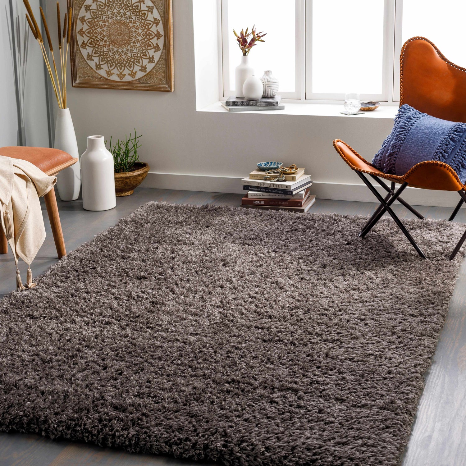 Living room scene with a charcoal Siari Solid Shag Rug, leather chair, and neutral decor. Roomscene-Rectangle