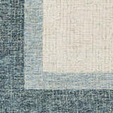 Close-up of the hand-tufted Padada Green Bordered Cream Wool Rug showing its textured cream center and blue border. Swatch