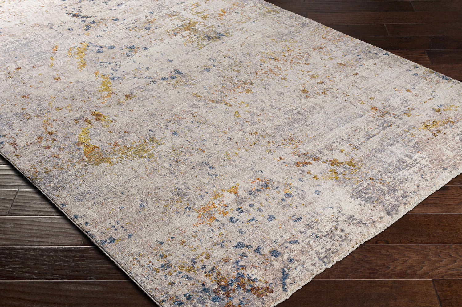 Close up of Palhi Area Carpet showing brick red, cream, blue, and gray abstract design on dark wood floor. Corner