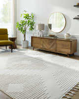 Living room scene with a Palimbang Cream 3D Rug, wooden console table, round mirror, and olive green chair. Roomscene-Rectangle