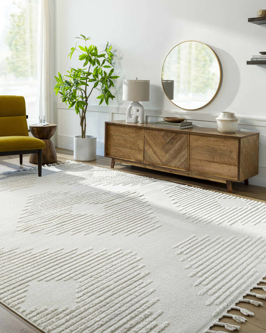Living room scene with a Palimbang Cream 3D Rug, wooden console table, round mirror, and olive green chair. Roomscene-Rectangle