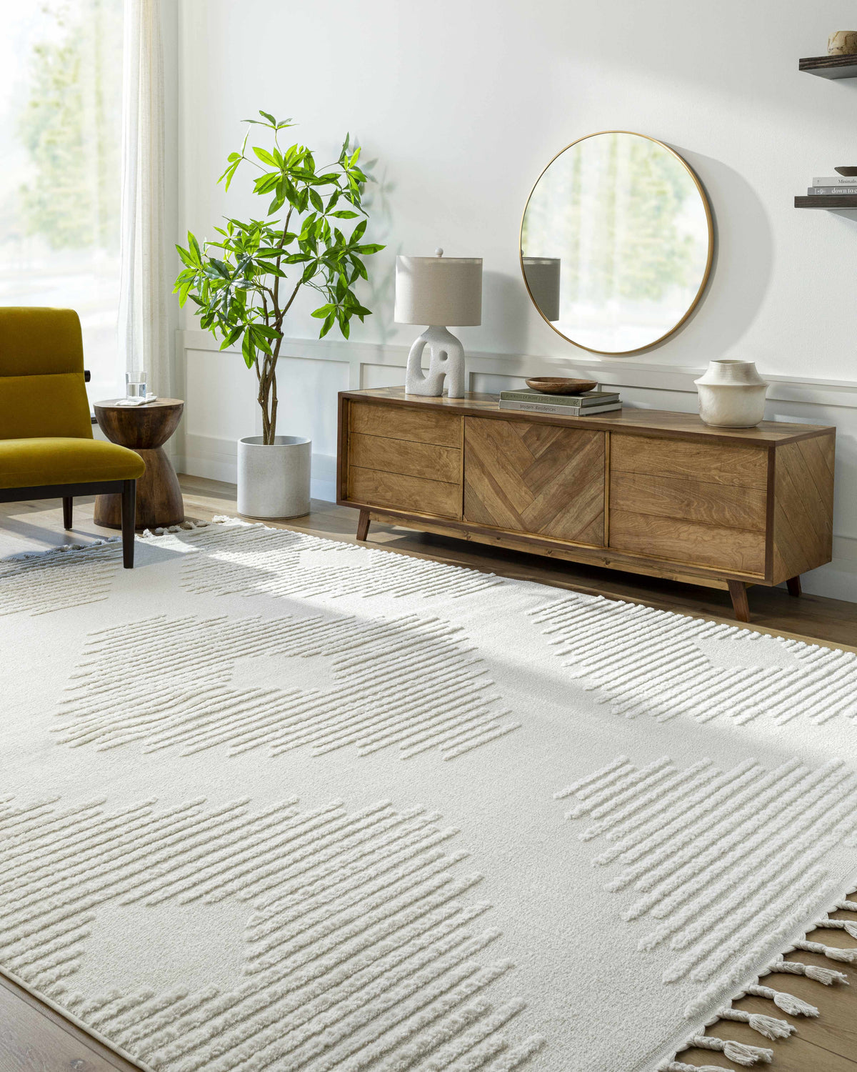 Living room scene with a Palimbang Cream 3D Rug, wooden console table, round mirror, and olive green chair. Roomscene-Rectangle