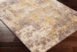 Close up of the Pamantingan Area Rug showing cream, beige, gray, brown and mustard tones on a dark wood floor. Corner