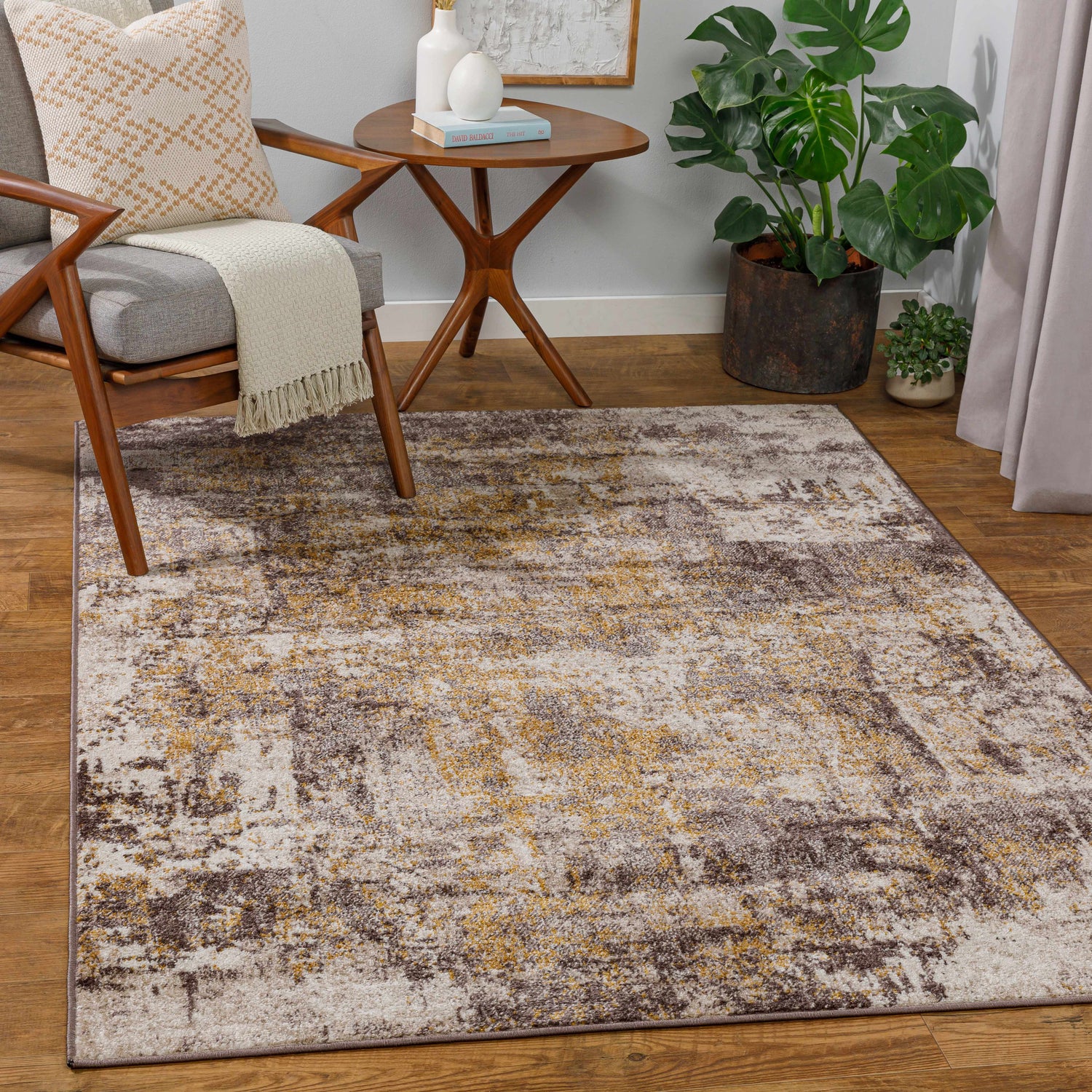 Living room scene with a Pamantingan Area Rug in cream, beige, brown, and mustard colors, styled with a chair and side table. Roomscene-Rectangle