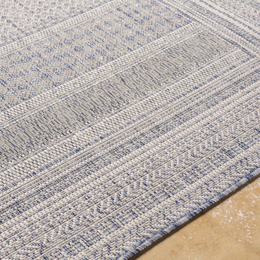 Close-up of the machine woven Panaytayon Area Rug, featuring a cream and navy geometric pattern. Texture