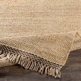 Close-up of the tan and medium brown Partoun Area Rug showing its hand-woven texture and fringed edge. Fold