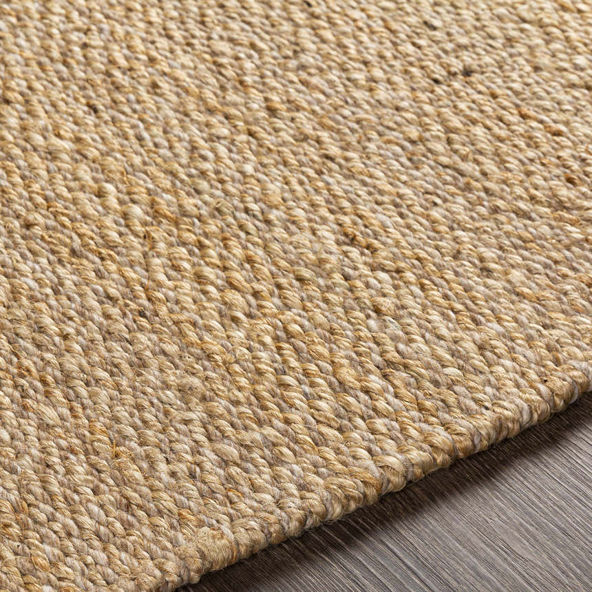 Close-up of the hand-woven Partoun Area Rug. Medium brown and tan jute rug with a contemporary design and natural texture. Texture