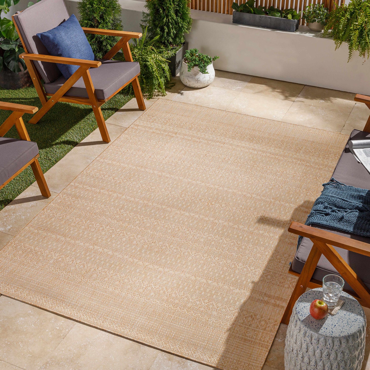 Outdoor patio scene with wood chairs and a cream Patayac Indoor & Outdoor Rug. Roomscene-Rectangle