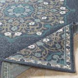 Close-up of the Penland Area Rug showing its navy, teal, taupe, and white traditional floral pattern and machine-woven texture. Fold