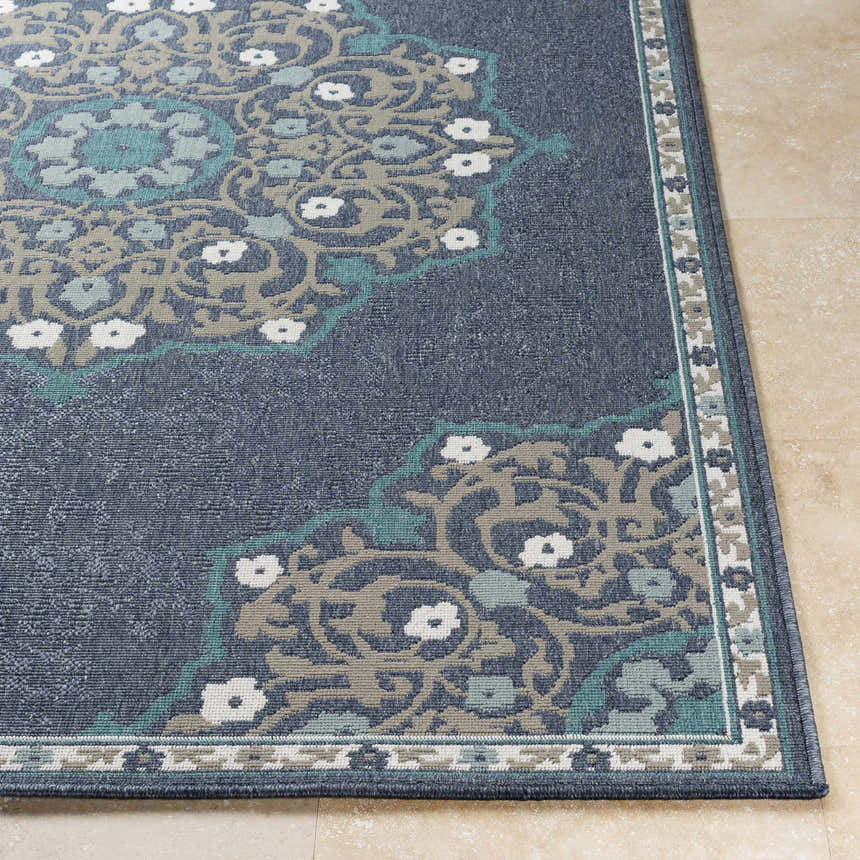 Close-up of the Penland Area Rug. Navy rug with pale blue, taupe, teal, and white floral medallion pattern. Machine woven olefin rug. Front