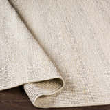 Close-up of the textured Penticton Cream Flat Woven Wool Rug, showcasing its beige, gray, and cream tones and hand-woven construction. Fold