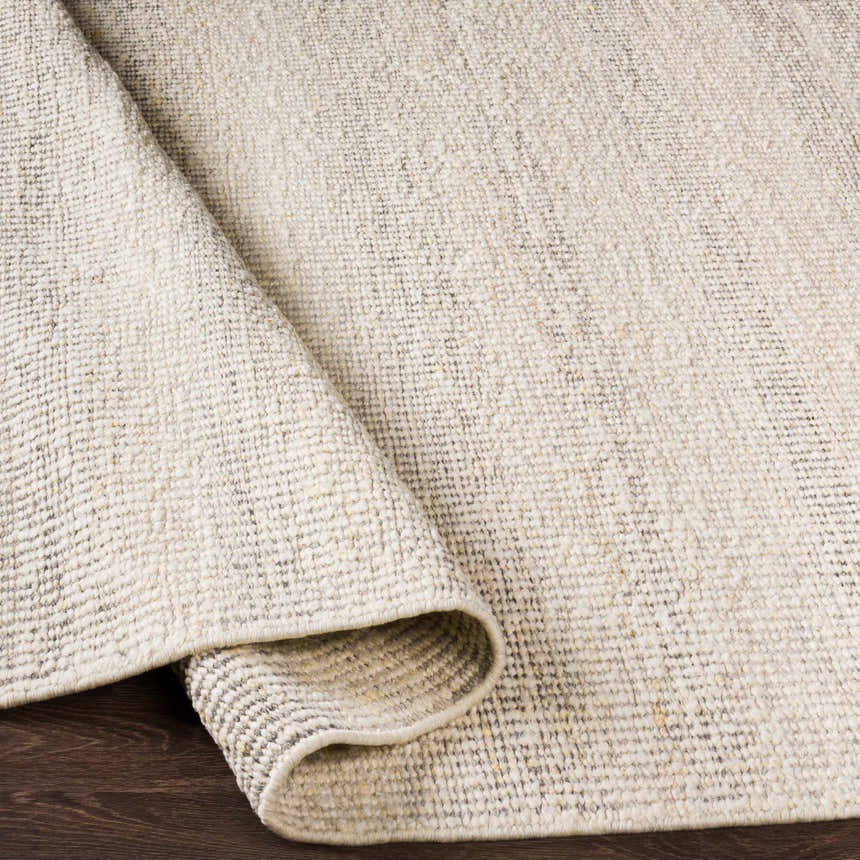 Close-up of the textured Penticton Cream Flat Woven Wool Rug, showcasing its beige, gray, and cream tones and hand-woven construction. Fold