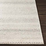Close-up of the textured Penticton Cream Flat Woven Wool Rug showing its cream, beige, and gray tones on a dark wood floor. Front