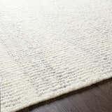 Close-up of the Penticton Cream Flat Woven Wool Rug showing its texture and flat weave construction on dark wood floor. Texture