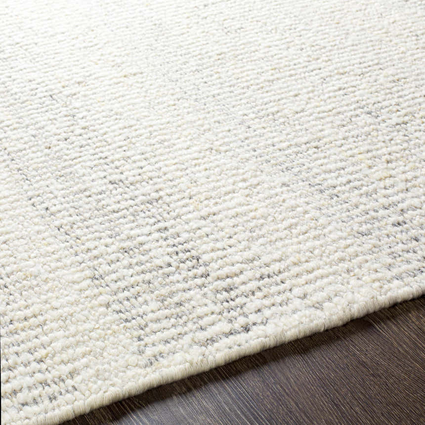 Close-up of the Penticton Cream Flat Woven Wool Rug showing its texture and flat weave construction on dark wood floor. Texture