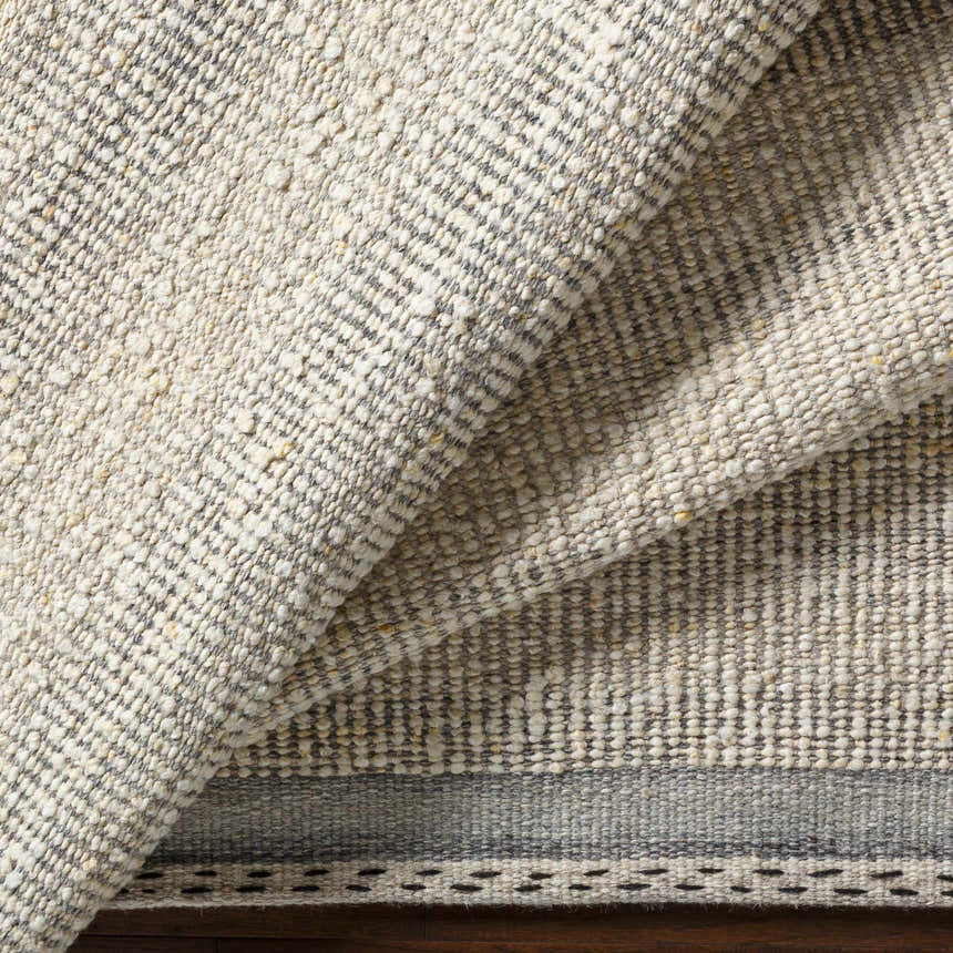 Close-up of the hand-woven Penticton Cream Flat Woven Wool Rug, showing its beige, cream, and gray tones and textured wool design. Fold