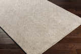 Close-up of the Phalaborwa Area Rug, a hand-loomed contemporary rug in gray, light beige, and tan, on a dark wood floor. Corner