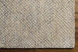 Close-up of Phalaborwa Area Rug showing its gray, light beige, and tan textured, hand-loomed design. Corner