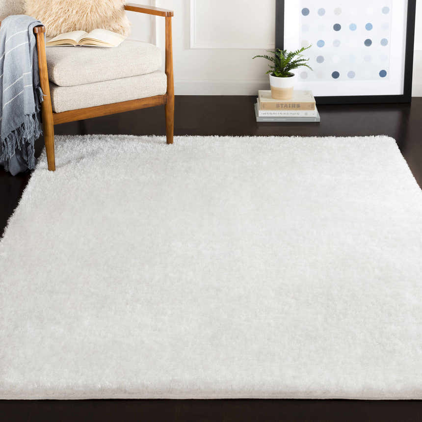 Living room scene with a fluffy white Piedmont Area Rug, chair, and dark wood floors. Roomscene-Rectangle