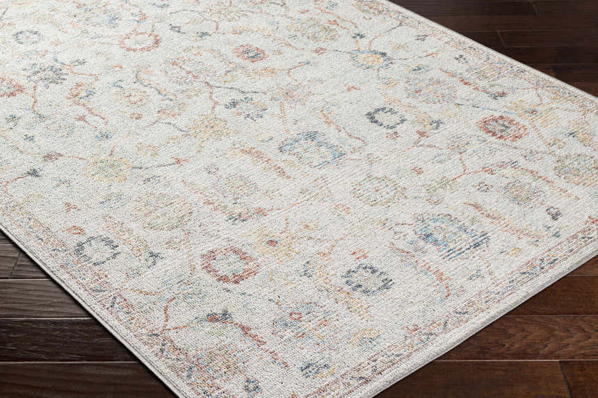 Close-up of Piera Washable Area Rug showing ash, gray, silver, and sterling grey traditional floral pattern. Corner