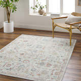 Living room scene with Piera Washable Area Rug in ash, light gray, silver. Farmhouse style with wood floors and woven chair. Roomscene-Rectangle
