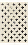 Close-up of the Anda Black on White Moroccan Plush Rug. Features a black plus sign pattern on a cream-colored, textured background. Tassels on the edge. Design-Rectangle-537