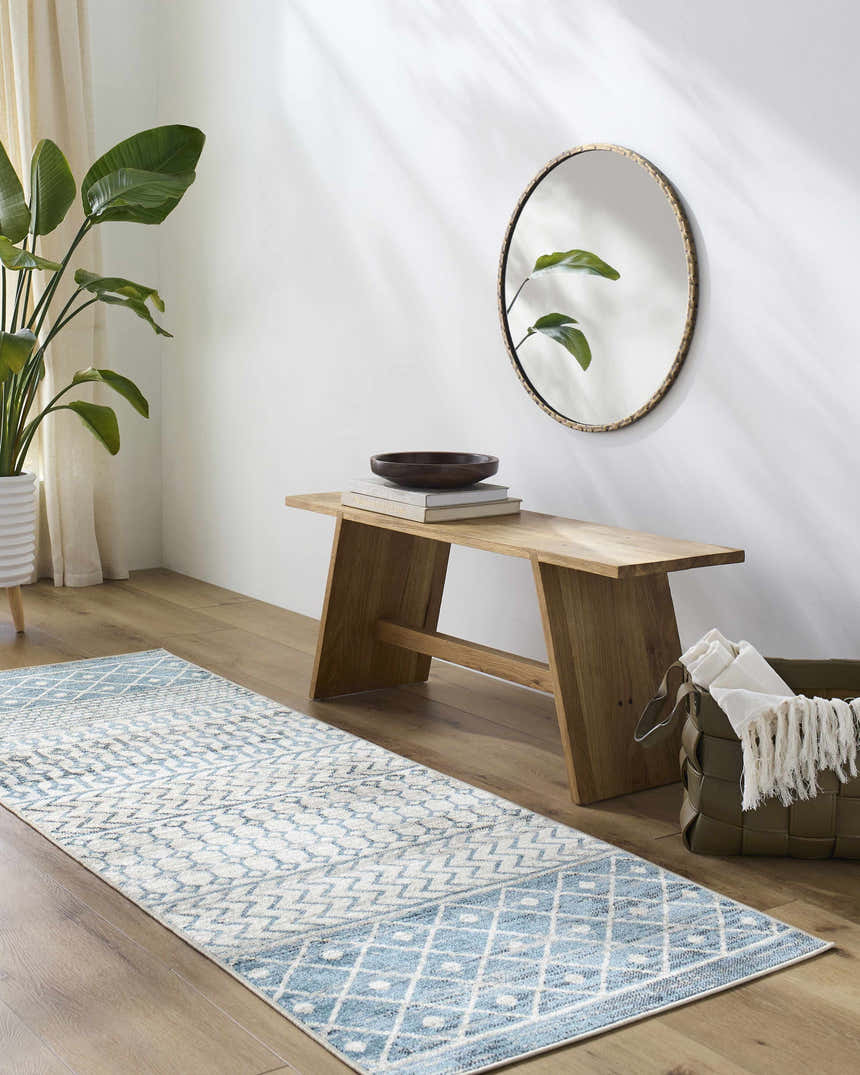 Entryway with Pinamopoan Washable Area Rug in blue and beige, wood bench, round mirror, and green plant. Roomscene-Runner