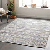 Living room scene with a beige and blue Pontian Area Rug, bench, plants, and natural light. Roomscene-Rectangle