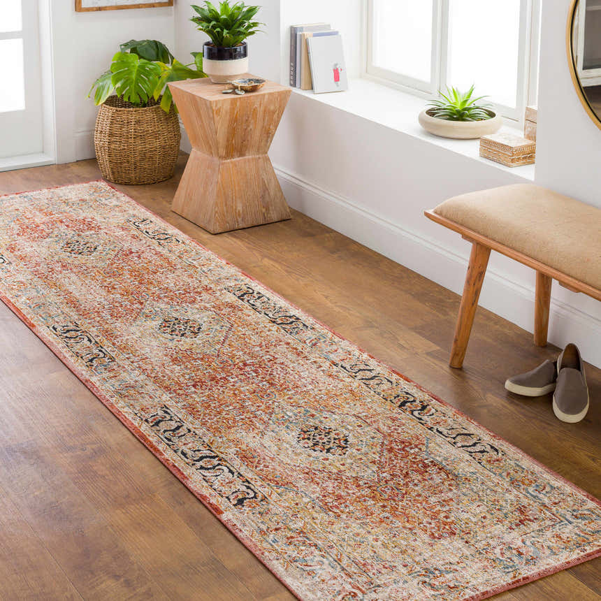 Hallway scene with a brick red Polomolok Luxe Performance Rug runner, wooden bench, plants, and natural light. Roomscene-Runner