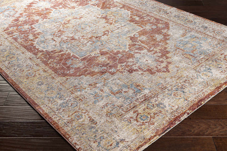 Close-up of the Powassan Area Rug showing its brick red, charcoal, and light beige traditional pattern. Corner