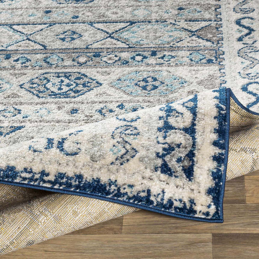 Close-up of the Purdys Area Rug showing its aqua, charcoal, and cream Bohemian-style pattern and texture. Fold