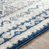 Close-up of the Purdys Area Rug showing its aqua, charcoal, and cream bohemian pattern and machine woven texture. Texture