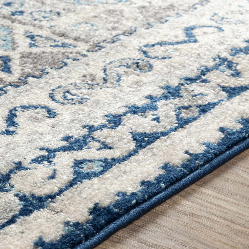 Close-up of the Purdys Area Rug showing its aqua, charcoal, and cream bohemian pattern and machine woven texture. Texture