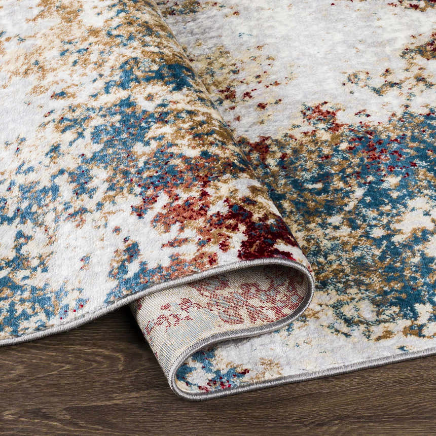 Close-up of the Prinza Area Carpet, a contemporary rug with dark gray, gray, natural gray, nutmeg, and taupe abstract pattern. Fold
