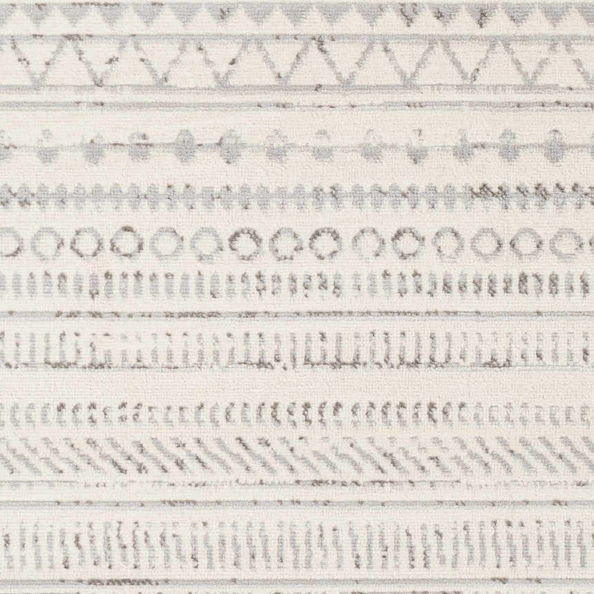 Close-up of Parmelia Area Rug showing off-white base and charcoal geometric tribal-inspired pattern. Swatch