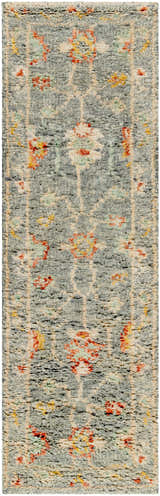 Close-up of the Prosperidad Handmade Wool Rug. Features a pale blue, brick red, and cream floral pattern with a textured, hand-knotted pile. Design-Runner-268