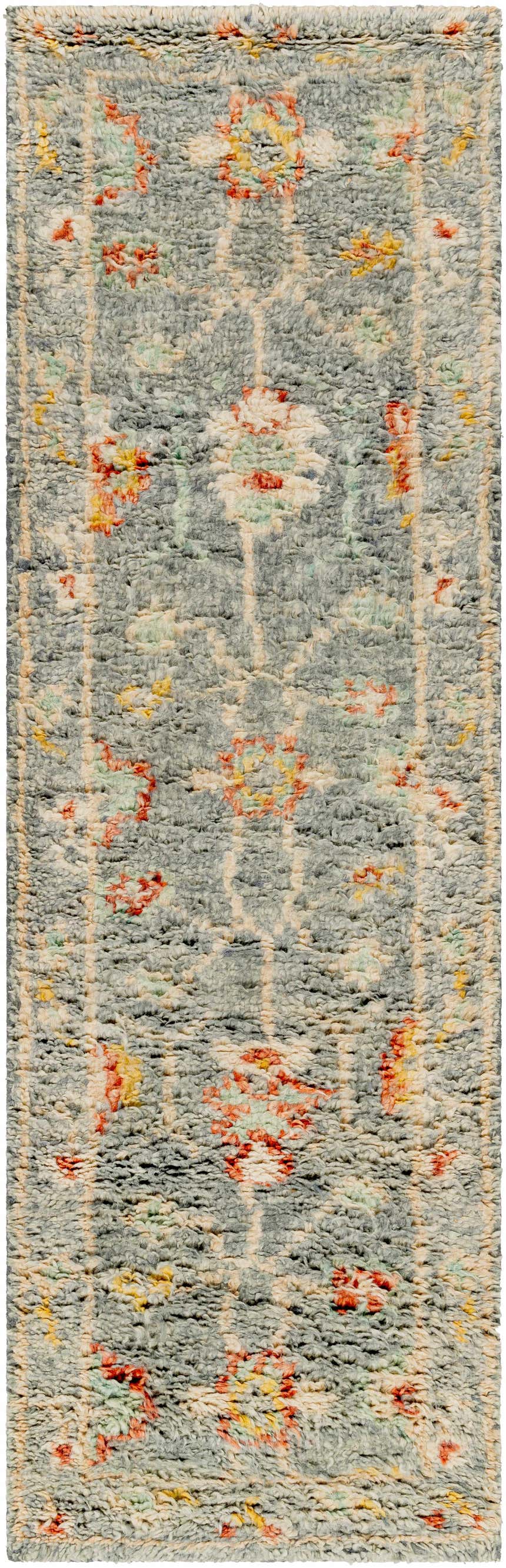 Close-up of the Prosperidad Handmade Wool Rug. Features a pale blue, brick red, and cream floral pattern with a textured, hand-knotted pile. Design-Runner-268