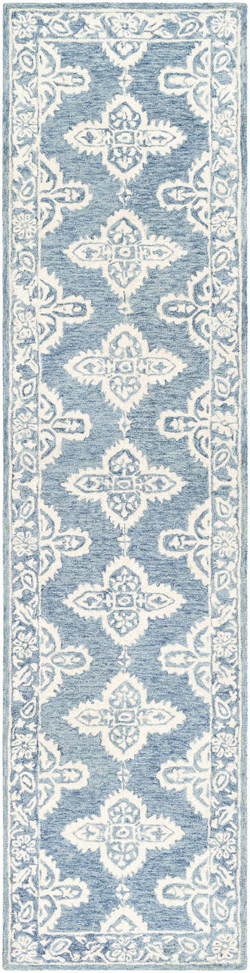 Close-up of the Passaic Hand Tufted Wool Rug. Blue rug with a traditional, light beige floral pattern and a hand-tufted texture. Design-Runner-2610