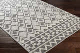 Close-up of the hand woven Post Area Rug. Bohemian style runner rug with a geometric design in ivory and black. Corner
