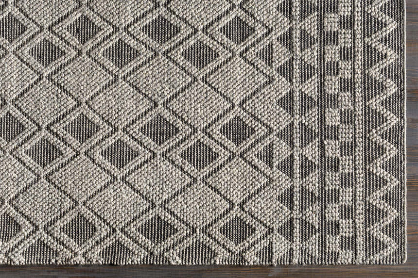 Close-up of the hand woven Post Area Rug, a wool runner with a black and white diamond pattern. Swatch