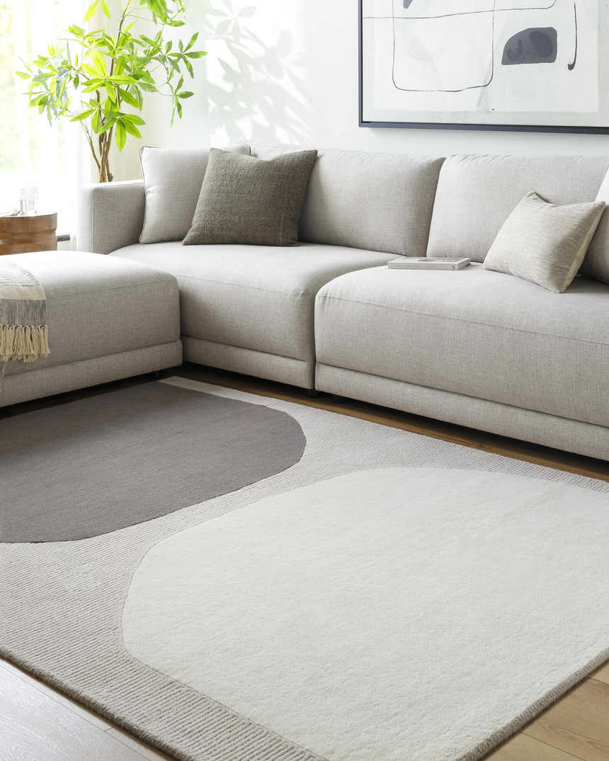 Living room scene with gray sectional sofa and Adhara Area Rug with gray and white geometric design. Roomscene-Rectangle
