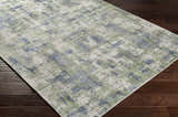 Close-up of the Pyle Area Rug on dark wood floors. Contemporary design in beige, blue, and sage green tones. Corner