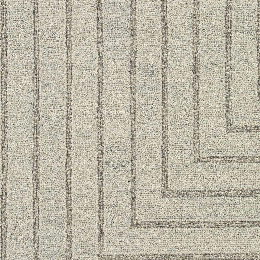 Close-up of the hand-tufted Queenton Area Rug. Charcoal and light gray wool with a geometric, mid-century modern design. Swatch
