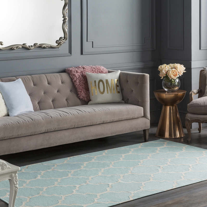 Living room scene with a Ragan Ice Blue Trellis Cotton Rug, gray walls, and a beige sofa with decorative pillows. Roomscene-Rectangle