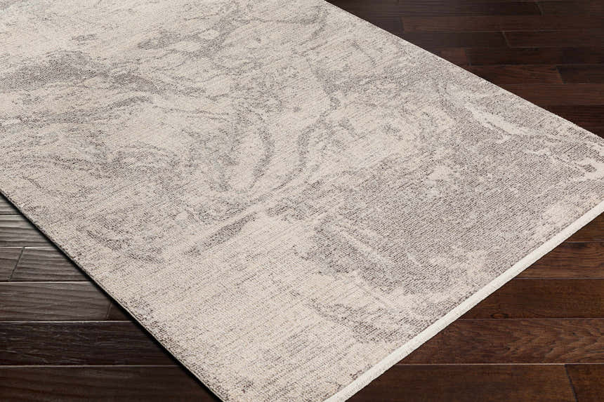 Close-up of Rahm Ivory Marble Area Rug showing its ivory and charcoal marble-like pattern and machine-woven texture. Corner