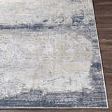 Close-up of the Rainworth Modern Slate Luxe Rug, showing charcoal, beige, and blue abstract pattern and machine-woven texture. Front