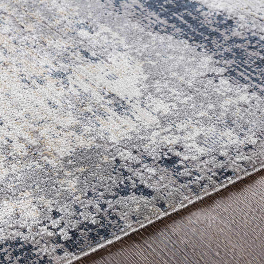 Close-up of the Rainworth Modern Slate Luxe Rug showing its charcoal, gray, and blue abstract pattern and soft texture. Texture