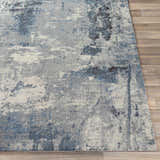Close-up of Ramsbottom Area Rug. Contemporary design in black, blue, charcoal, and cream on a wood floor. Front